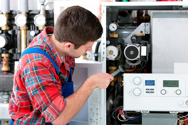 HVAC technician inspecting and repairing boiler controls in American Fork