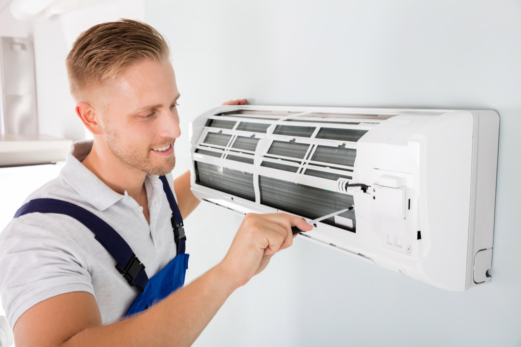 HVAC technician performing ductless air conditioning maintenance in American Fork