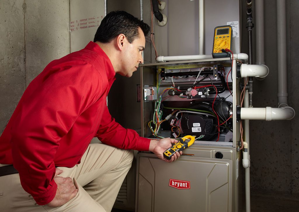 HVAC technician repairing an indoor furnace in American Fork