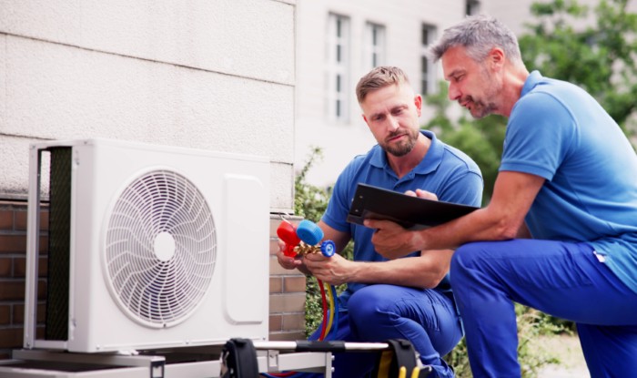HVAC technicians installing an outdoor air conditioning unit in American Fork