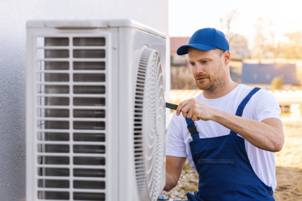 HVAC technician servicing an outdoor air conditioning unit in American Fork