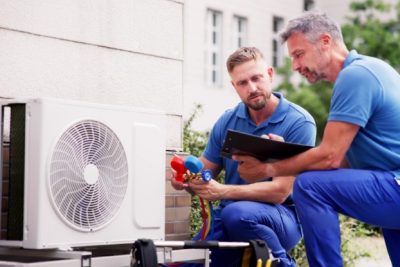 ac-installation-in-claremont-ca HVAC technicians reviewing an outdoor air conditioning unit in American Fork, UT