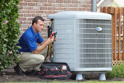 design-air-heating-and-air-conditioning-decatur-il-05 – Copy HVAC technician inspecting an outdoor air conditioning unit in American Fork, UT